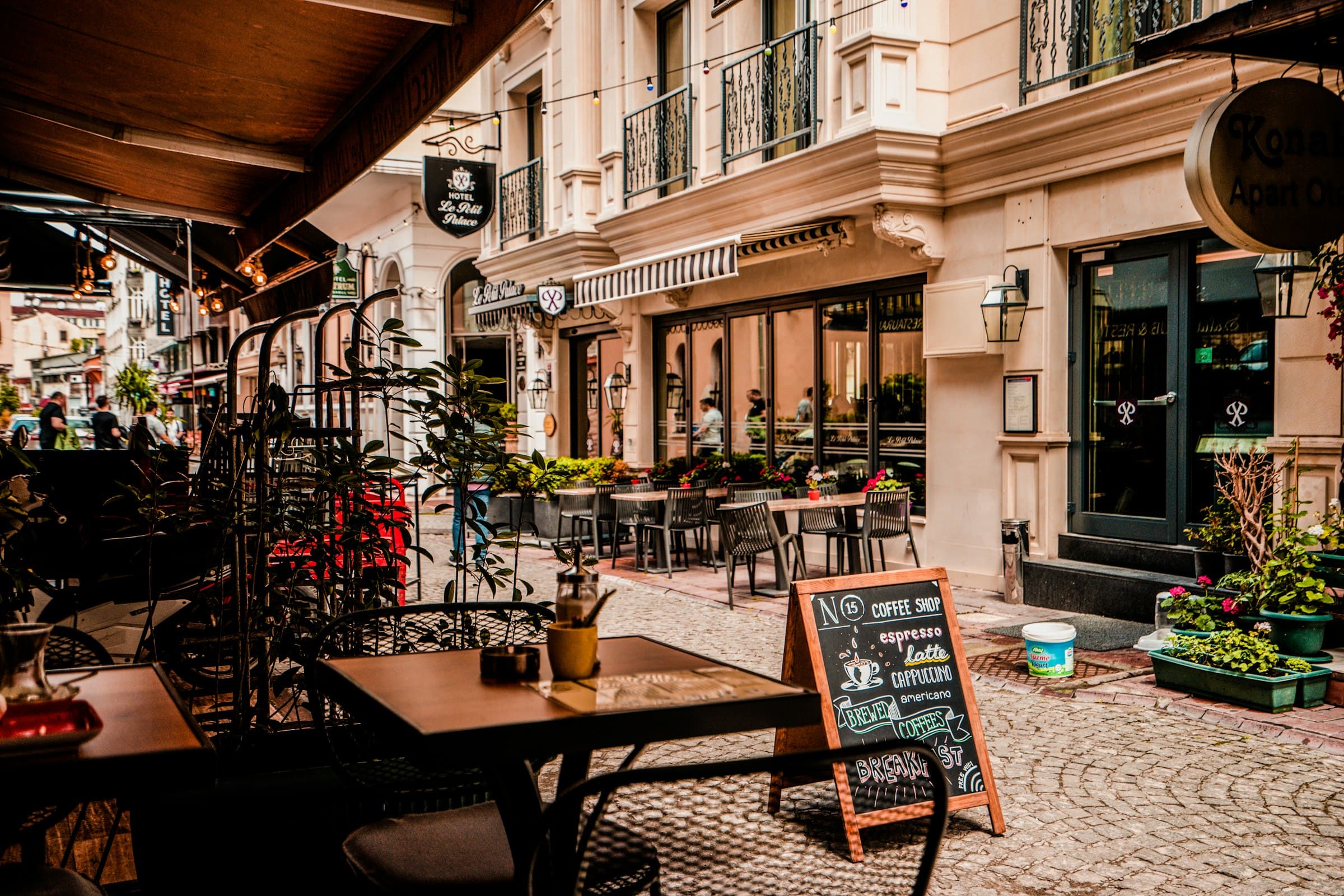 Luxury outdoor bistro streetfront patio with tables, chairs, and large dining umbrellas